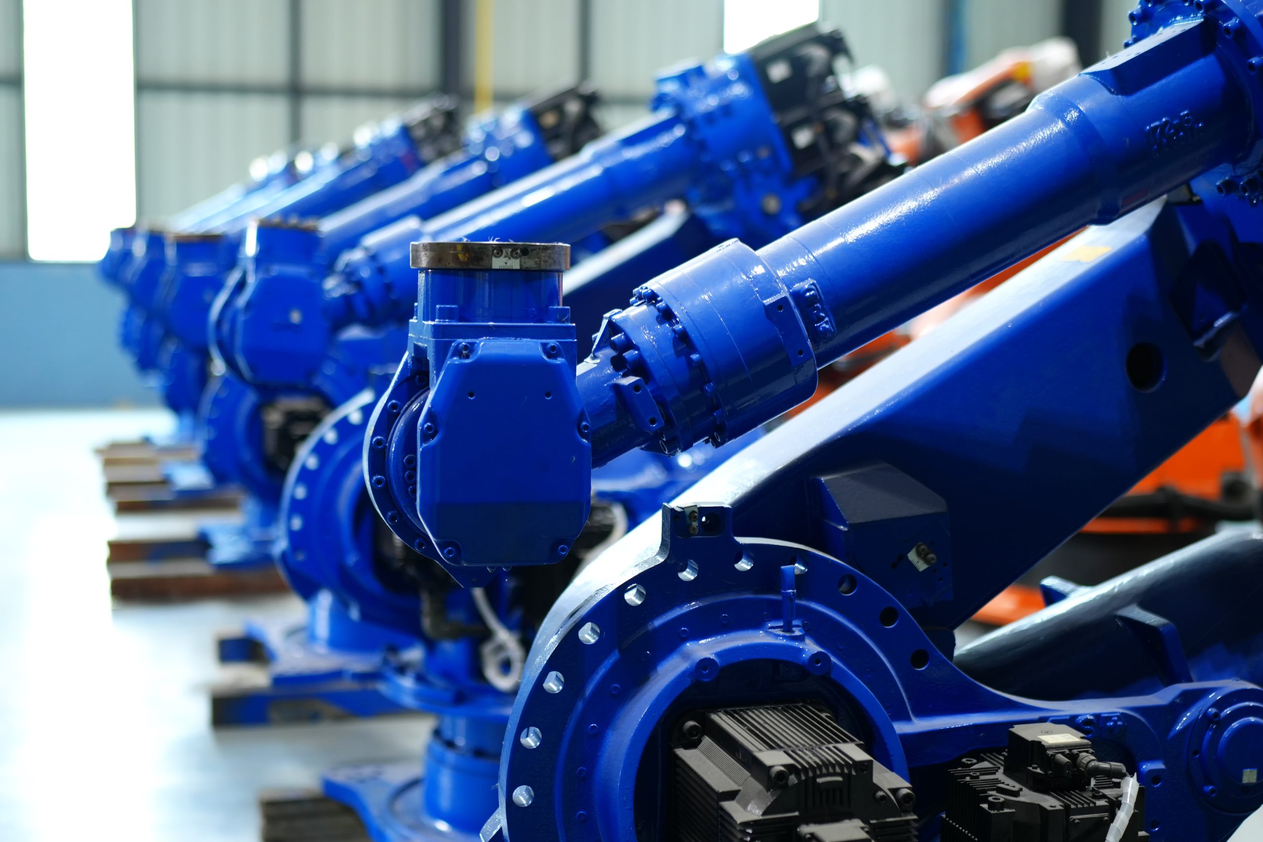 Robotic arm in futuristic assembly manufacturing factory, in factory shop floor.